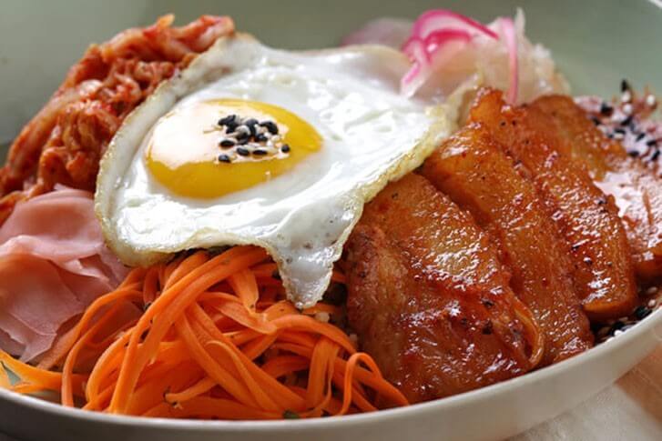 Kimchi and pickled vegetables—both gut health heroes— star in this satiating, craveable Seared Pork Belly Breakfast Bowl.