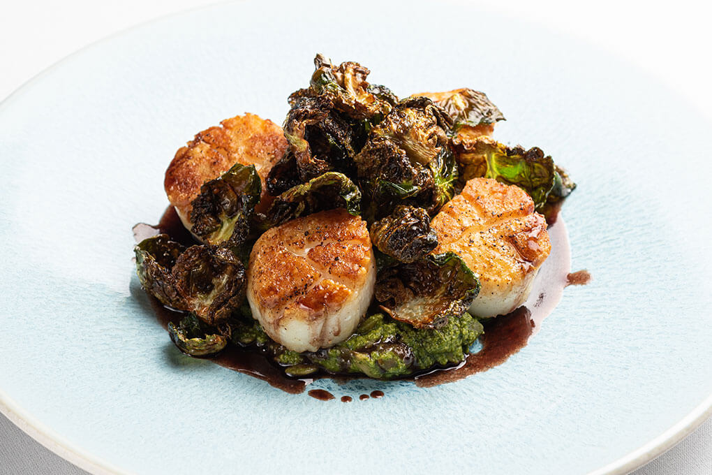 Seared Diver Scallops with pepita risotto, pomegranate beurre rouge and crispy Brussels sprouts leaves