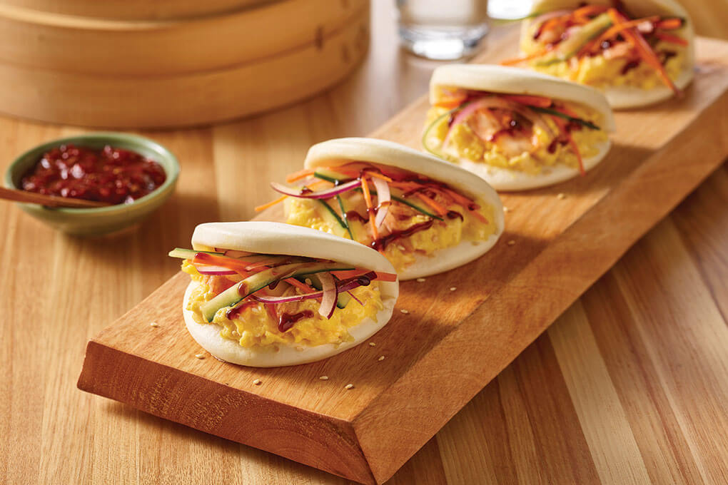 Soft, pillowy Chinese bao buns serve as the carrier for soft-scrambled eggs and pickled vegetables dashed in oyster sauce in these Egg Bao sandwiches.