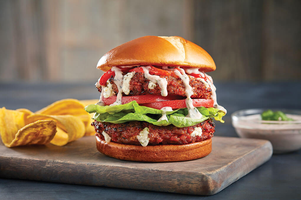 Maira Morales’ take on a Cuban frita features two beef-and-chorizo patties stuffed with soft cheese, topped with pimento peppers. tomato and butter lettuce, and served on a brioche bun.