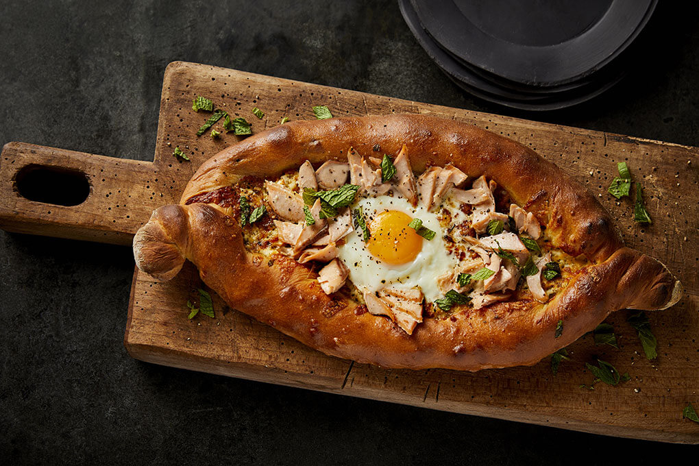 Vitaly Paley leverages the comfort-centric goodness of this boat-shaped Georgian carrier to create a memorable brunch item with his Adjaruli Khachapuri with Kippered Alaska Salmon.