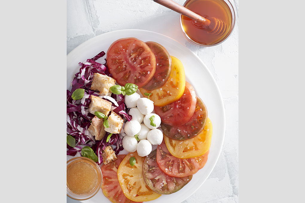 Seasonal heirloom tomatoes, fresh bocconcini mozzarella, with a honey and Meyer lemon dressing and honey-coated croutons.