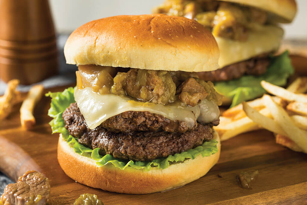 Look to flavorful stews as a way to introduce a premium—and hearty—component in unexpected places. Here, chunks of green chile verde-braised pork serve as a rich protein topper in a satisfying burger build.