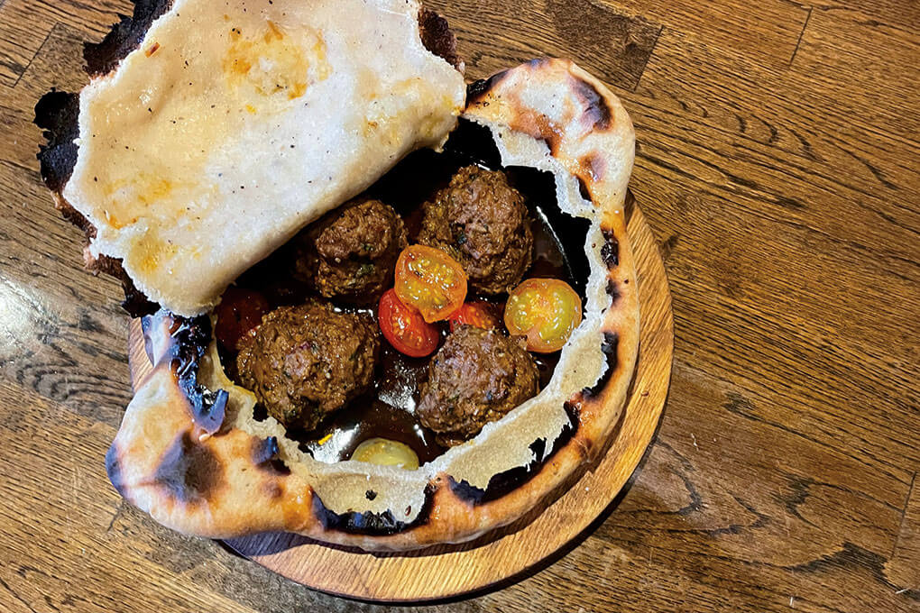 Lamb meatballs, tomatoes and a spicy red pepper sauce are the tasty surprise at the center of Fiya’s baked Kofta en Croute.
