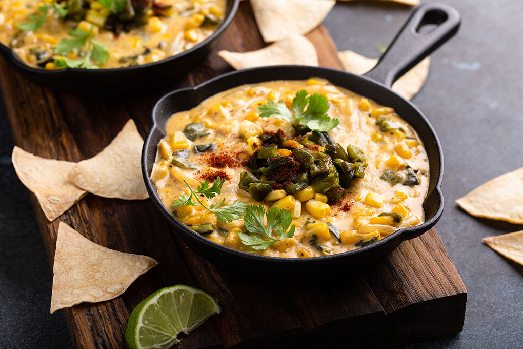 Creamy and craveable dips like this cheesy corn and green chile version are an inviting platform for a kick of heat.