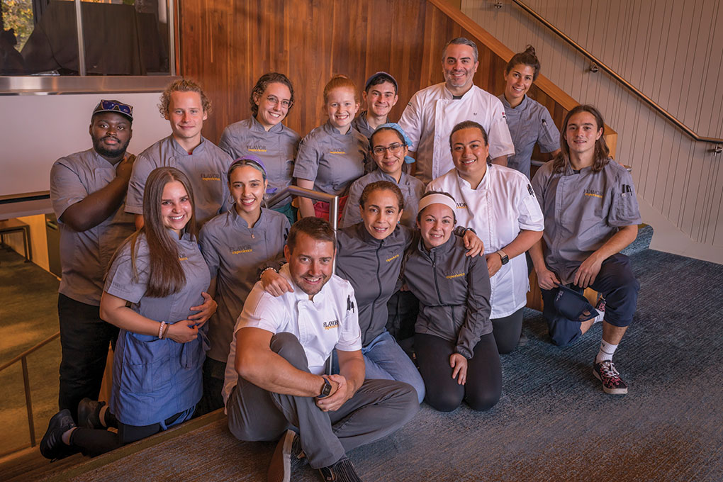Led by chefs Josh Ogrodowski and Valeria Molinelli (front row, from left), the Flavor Experience’s culinary workforce is made up of Flavor alums like TJ Delle Donne (standing, in white jacket) and Johnson & Wales University culinary students.