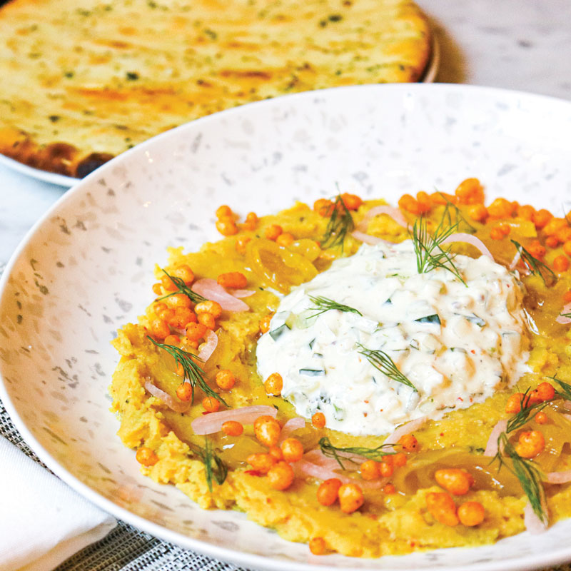 Classic dips combine in the Refried Dal Dip at Houston’s Georgia James Tavern, topped with cucumber raita and served with garlic naan.