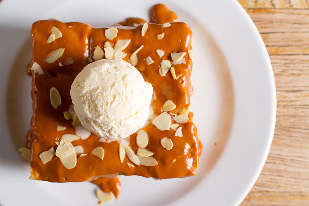 Sticky toffee bread pudding welcomes Thai iced tea’s flavors, bringing in Thai tea syrup and a condensed milk icing.