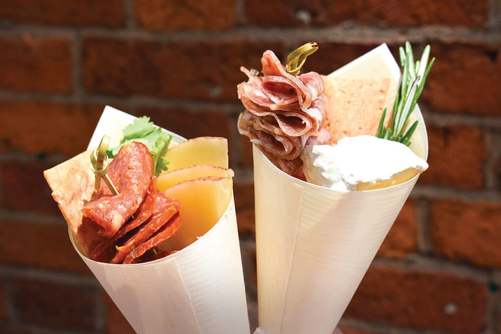 Boston’s quick-serve Kured menus charcuterie in portable cones, such as Madrileño (left) with Ibérico chorizo, manchego, sesame crackers and rosemary, and Italiano (right), with Genoa salami, Brie, sesame crackers and rosemary.