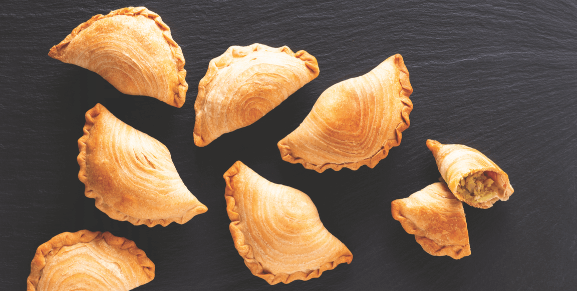 Southeast Asian curry puffs, typically filled with chicken and potato curry, are marked by flaky, laminated dough.