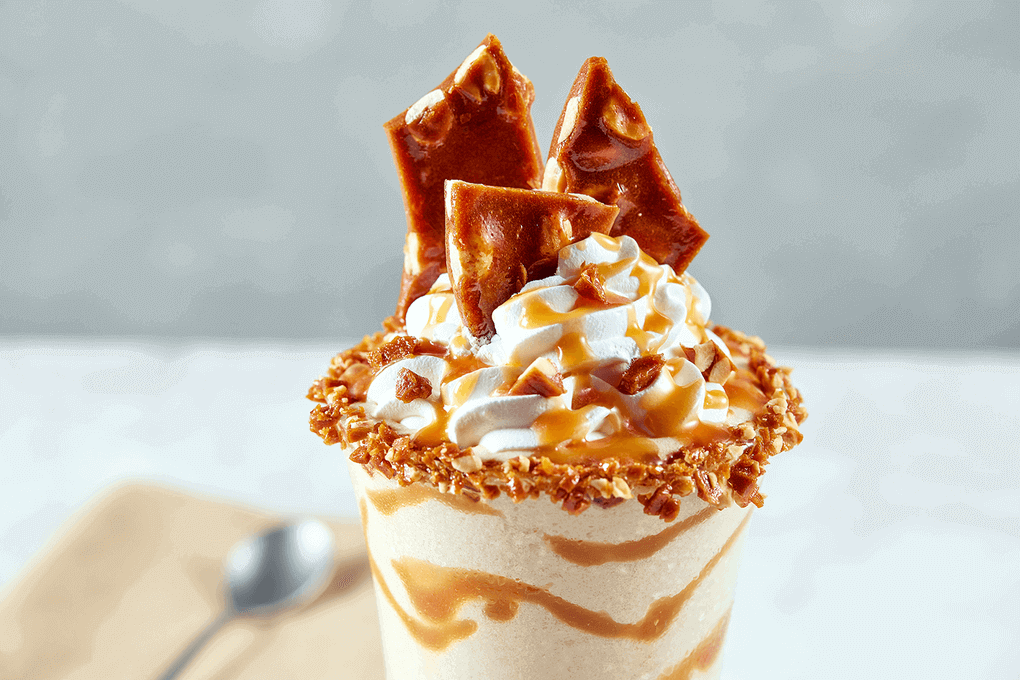 An adult take on a classic. Mezcal, vanilla bean ice cream, peanut butter, and salted caramel made with Kikkoman® Gluten-Free Tamari Soy Sauce, all blended and topped with more Tamari salted caramel and a Tamari peanut brittle.