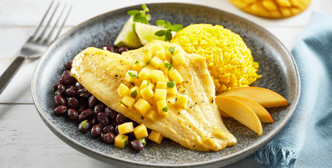Mango-marinated flounder is grilled to perfection, served over black beans and rice and garnished with fresh-diced mango and cilantro.
