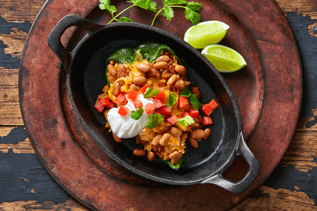 Poblano peppers are stuffed with southwest-style chicken, beans & rice, then roasted and garnished with fresh Roma tomatoes, cilantro and sour cream.