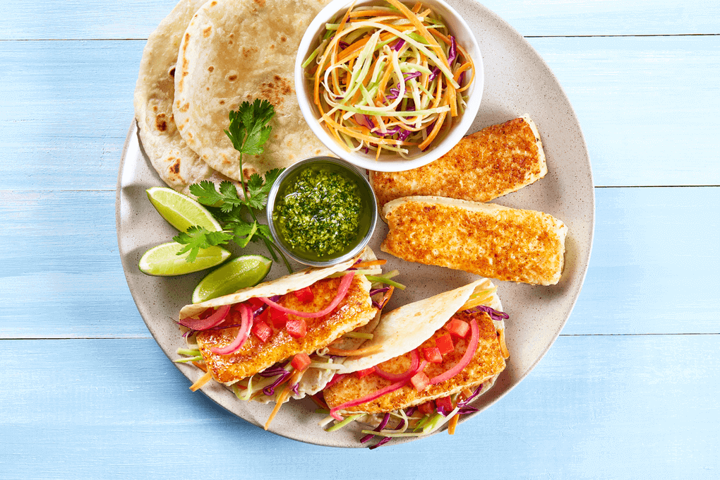 This craveable meat-free taco features pan-seared panela cheese on a flour tortilla with pickled onions and broccoli slaw, drizzled with cilantro pesto.