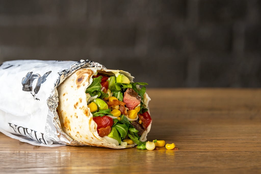Piada offers a robust menu of handhelds, including the Avocado Piada: artisan dough filled with pancetta, arugula, mozzarella, sweet corn, tomato and fresh avocado, finished with a bright basil aïoli